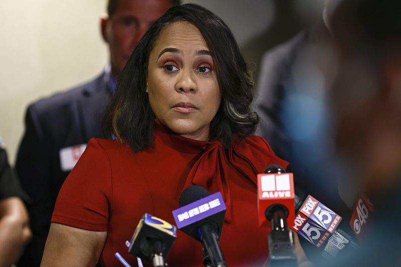 Surrounded by Fulton County law enforcement officials, District Attorney Fani Willis speaks during a press conference about the RICO indictment in the celebrity home invasion ring on Monday, August 29, 2022. (Natrice Miller/ natrice.miller@ajc.com). 