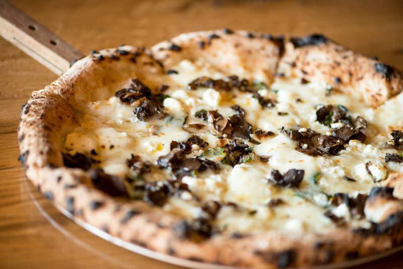 Ammazza Decatur Terra Pizza with wild mushrooms, goat cheese, house mozzarella, fresh basil, and truffle oil. Photo credit- Mia Yakel.