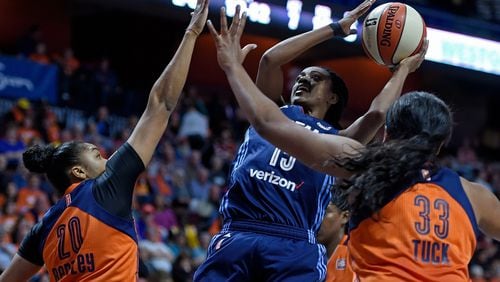 The Dream’s Tiffany Hayes shoots over a pair of Connecticut defenders in the WNBA opener for both teams Saturday. (Sean Elliot, The Day via AP)