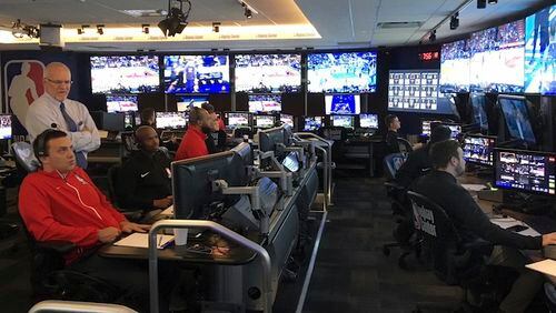 Joe Borgia, NBA Senior Vice President of replay and referee operations, second left, talks to senior replay manager Monte Shubik left, at the National Basketball Association Replay Center in Secacus N.J., Thursday, Nov. 15, 2017. They are in the games, just not at the games. The referees in the NBA's Replay Center are far from the action but yet right in the middle of it, potentially making rulings on the most important plays of the night from their desk in a New Jersey office park. NBA referee Dedric Taylor is third from left. (AP Photo/Brian Mahoney)