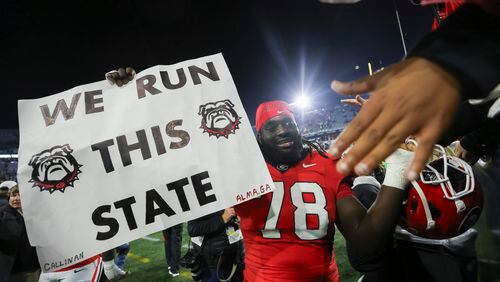 Georgia defensive lineman Nazir Stackhouse (78) holds a “We Run This State” sign as he greets fans after Georgia’s 31-23 win against Georgia Tech at Bobby Dodd Stadium, Saturday, November 25, 2023, in Atlanta. (Jason Getz / Jason.Getz@ajc.com)