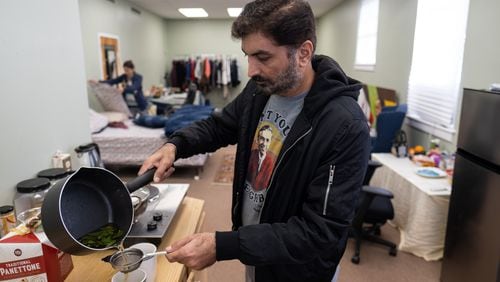 Anand Sawlani pours mint tea as his wife Kiran Nawani makes the bed. The couple are asylum seekers from Pakistan, and are living in a converted room at Columbia Presbyterian Church in Decatur. Ben Gray for the Atlanta Journal-Constitution