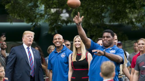President Donald Trump watches Herschel Walker, the retired football star, throw a pass at the White House Sports and Fitness Day, in Washington, May 30, 2018. Standing with Trump are Mariano Rivera, the retired New York Yankees closer; and Ivanka Trump. (Doug Mills/The New York Times)
