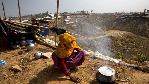 In this Saturday, Jan. 13, 2018, photo, a newly arrived Rohingya woman makes rice for her family at Balukhali refugee camp near Cox's Bazar, Bangladesh. (AP Photo/Manish Swarup)