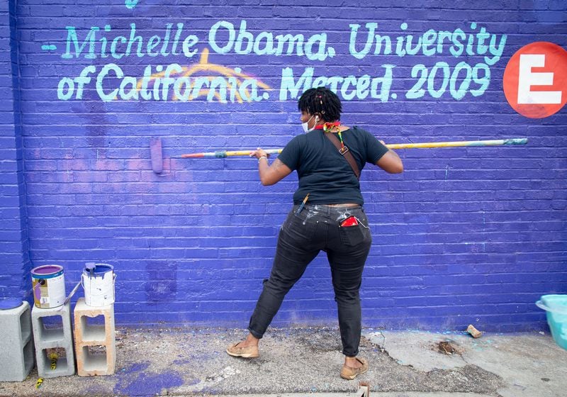LaShebia Mayes covers over graffiti that was painted on the HEROINE Mural the night before in Atlanta Saturday, September 19, 2020.   STEVE SCHAEFER / SPECIAL TO THE AJC 