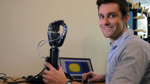 Johns Hopkins University’s biomedical engineering graduate student Luke Osborn with an “e-dermis” device that was developed, using an “electronic skin” to help amputees experience physical sensations. (Karl Merton Ferron/Baltimore Sun/TNS)