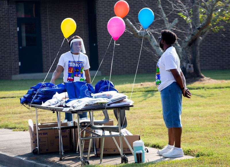 Fourth great teachers Veronica Williams, left, and Cheryl Long wait for cars to hand out free school supplies at Kemp Elementary in Hampton, Georgia on August 8, 2020.  STEVE SCHAEFER FOR THE ATLANTA JOURNAL-CONSTITUTION