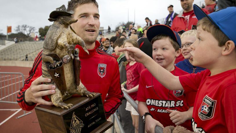Bobby Boswell of D.C. United holds the ATX Pro Challenge trophy, an armadillo wearing a cowboy hat and toting pistols.