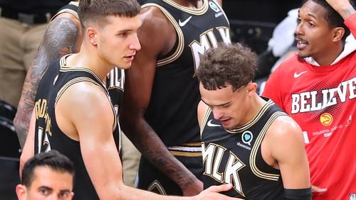 Hawks guard Bogdan Bogdanovic bucks up teammate Trae Youne Saturday night after the Hawks were eliminated by the Milwaukee Bucks in the Eastern Conference Finals.   “Curtis Compton / Curtis.Compton@ajc.com”