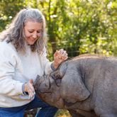 Laura Jensen is seen with Poppy Pickles, a Meishan hog that has become the farm mascot. Courtesy of Mary Ann Morgan Photography
