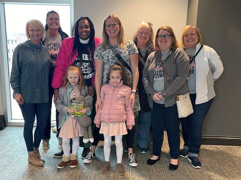 Teachers at Pitner Elementary School in Acworth pose with the two recently adopted members of the Rager family on the day of the girls' adoption in Cobb County. Photo courtesy of Lisa Rager