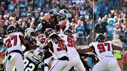 CHARLOTTE, NORTH CAROLINA - DECEMBER 23: Christian McCaffrey #22 of the Carolina Panthers jumps for the goal line against Deion Jones #45 of the Atlanta Falcons in the first quarter during their game at Bank of America Stadium on December 23, 2018 in Charlotte, North Carolina. (Photo by Grant Halverson/Getty Images)