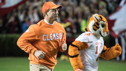 Clemson head coach Dabo Swinney runs onto the field  with one of his friends before last week's victory over rival South Carolina. (AP Photo/Sean Rayford)