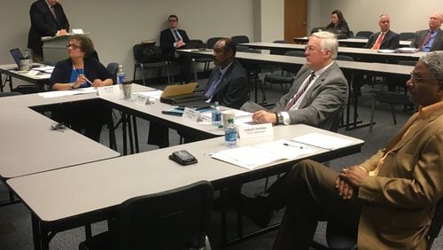 Gwinnett County ethics board members (from left) Terri R. Duncan, Herman Pennamon, David Will and Charles Rousseau watch a video on the county's ethics ordinance Friday.
