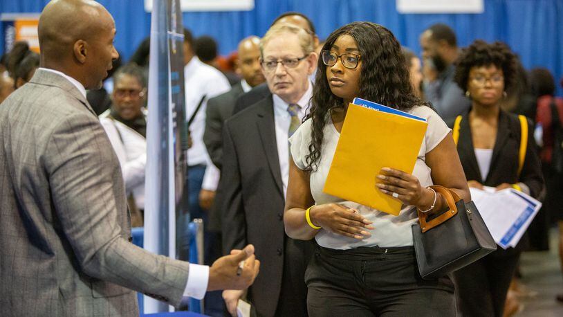 Job growth in metro Atlanta has been substantial, so finding a job is much easier than a few years ago. But finding one that pays well is harder. Here, FBI Special Agent, recruiter Charles Orgbon Jr (left) talks with Desiree Harvey-Lovell during a recent job fair at the Georgia International Convention Center. (Photo by Phil Skinner)