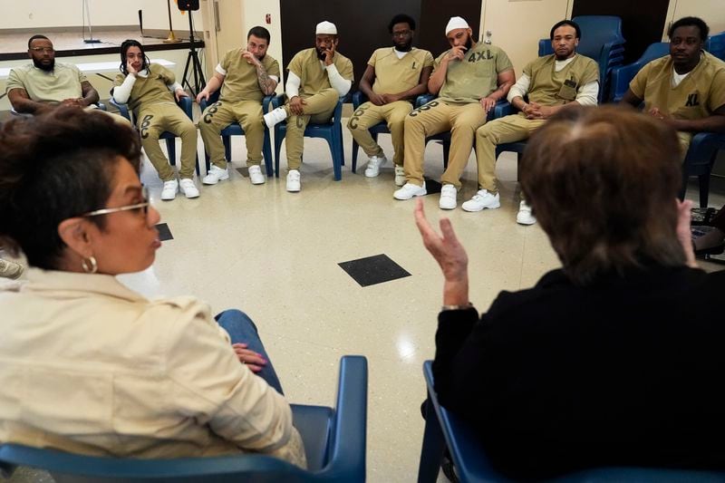 Sister Helen Prejean, bottom right, talks during a book club as Georgianna Torres Reyes, left, and detainees listen at Department Of Corrections Division 11 in Chicago, Monday, April 22, 2024. DePaul students and detainees are currently reading Dead Man Walking and the author, anti death penalty advocate, Sister Helen Prejean attended to lead a discussion. (AP Photo/Nam Y. Huh)