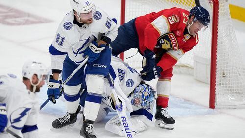 Florida Panthers center Carter Verhaeghe (23) skates into Tampa Bay Lightning goaltender Andrei Vasilevskiy (88) as defenseman Erik Cernak (81) looks on during the second period of Game 2 of the first-round of an NHL Stanley Cup Playoff series, Tuesday, April 23, 2024, in Sunrise, Fla. Verhaeghe was charged with goaltender interference. (AP Photo/Wilfredo Lee)