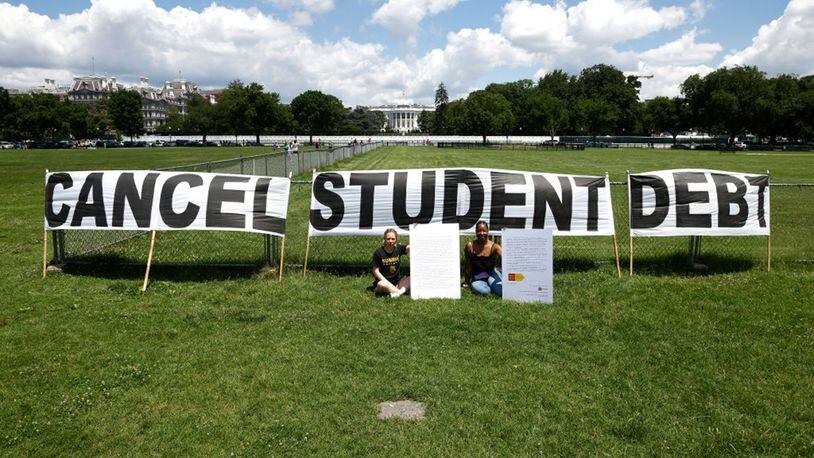 As college students around the country graduated with a massive amount of debt, advocates displayed a hand-painted sign and messages on the Ellipse in front of the White House in June. (Paul Morigi/Getty Images/TNS)