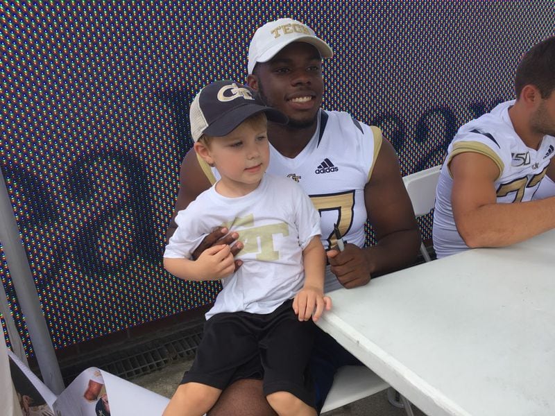Georgia Tech punter Pressley Harvin poses for a photo with a young fan at the team's fan day August 3, 2019, at Bobby Dodd Stadium. (Ken Sugiura/AJC)