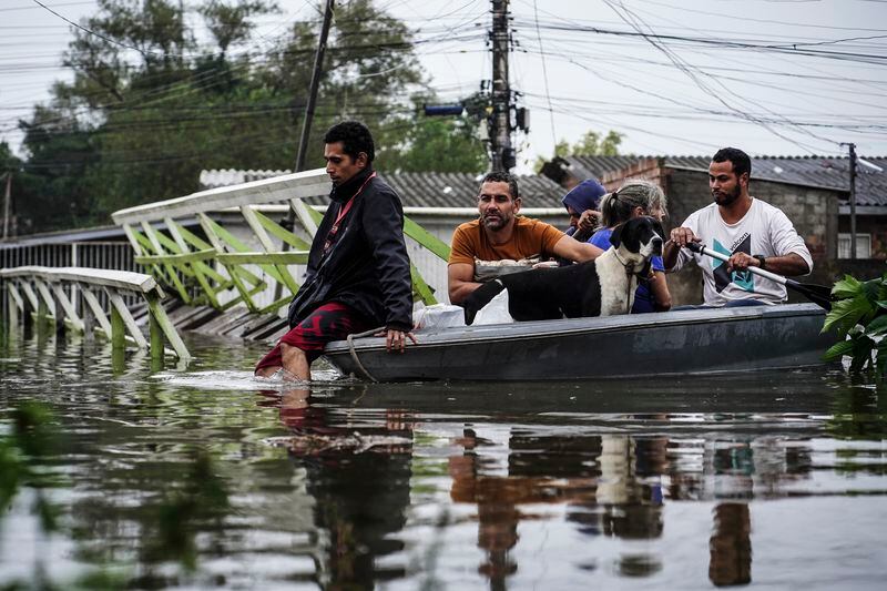 People evacuate an area flooded by heavy rains, in Porto Alegre, Rio Grande do Sul state, Brazil, Friday, May 3, 2024. (AP Photo/Carlos Macedo)