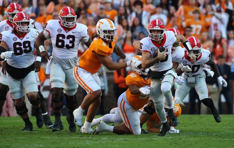 Georgia quarterback Brock Bowers breaks free from Tennessee defenders for a first down gain during the first quarter in a NCAA college football game on Saturday, Nov. 18, 2023, in Knoxville.  Curtis Compton for the Atlanta Journal Constitution