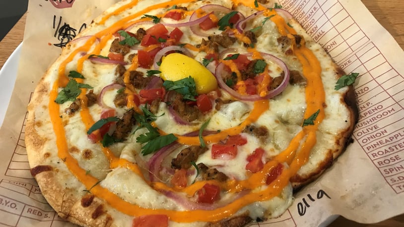 At MOD Pizza, you can build your own or try one of the restaurant’s creations, including a seasonal pie such as Ella (pictured) that holds white sauce, mozzarella, spicy chicken sausage, diced tomatoes, red onion, cilantro, a lemon wedge and Sriracha. LIGAYA FIGUERAS / LFIGUERAS@AJC.COM