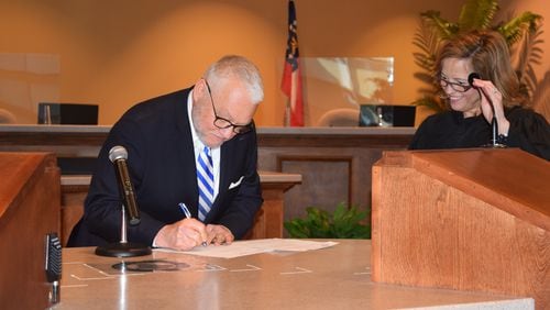 Probate Judge Kelley Powell on Monday swears in Greg Cannon as Henry's interim District 3 county commissioner. (PHOTO: HENRY COUNTY COMMISSION)