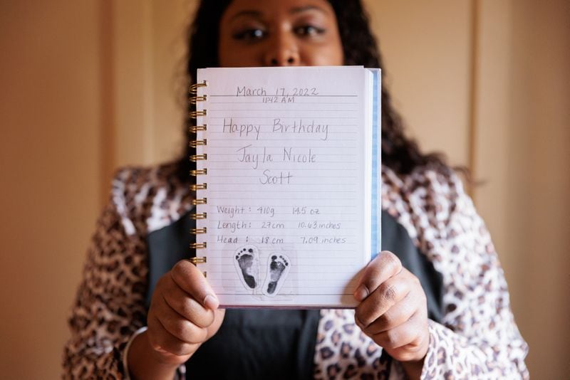Audreona Scott shows a diary entry welcoming Jayla into the world. Jayla’s nurses helped Scott write the diary while the infant was in the hospital. (Arvin Temkar / arvin.temkar@ajc.com)