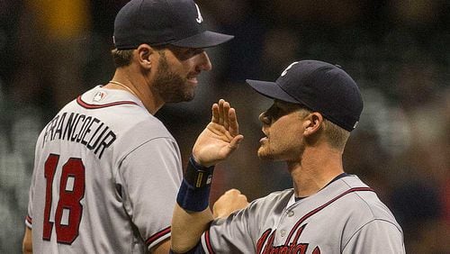 Gordon Beckham, who delivered the key sacrifice fly in the 12th, celebrates with Jeff Francoeur after the Braves' 4-3 win Monday.
