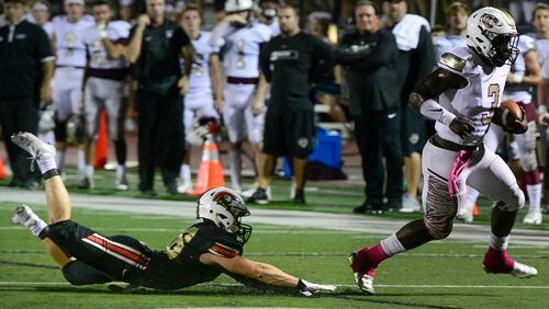GAC CB Sam Collins is left in the turf as Dawson Sevaughn Clark makes a touchdown run during a high school football game Friday, Oct.5, 2018, in Norcross. John Amis/Special