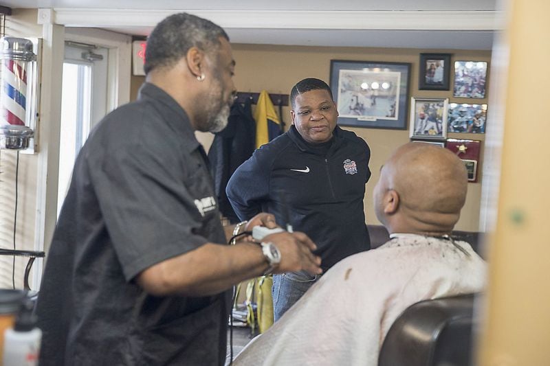 01/18/2019 — Atlanta, Georgia — Barber Maurice Combs (center) defends his stance on his love the Atlanta Falcons while speaking with a customer at Off The Hook Barber Shop in Atlanta’s Castleberry Hill community, Friday, January 18, 2019. Combs says he will be rooting for the New Orleans Saints if they make it to Atlanta for Super Bowl LIII. He hopes his cheering will curse the team as they play. (ALYSSA POINTER/ALYSSA.POINTER@AJC.COM)