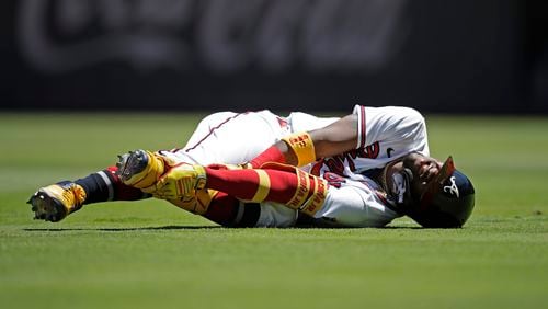 Atlanta Braves' Ronald Acuna Jr. grabs his left foot after falling in the seventh inning of a baseball game against the Toronto Blue Jays Thursday, May 13, 2021, in Atlanta. (AP Photo/Ben Margot)