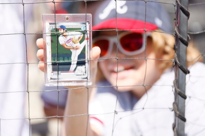 Abel Strodier of Columbus, Ga, holds a baseball card of Braves pitcher Spencer Strider, hoping to get it signed before the game against the Astros at Truist Park, Sunday, April 23, 2023, in Atlanta. 
Miguel Martinez / miguel.martinezjimenez@ajc.com 