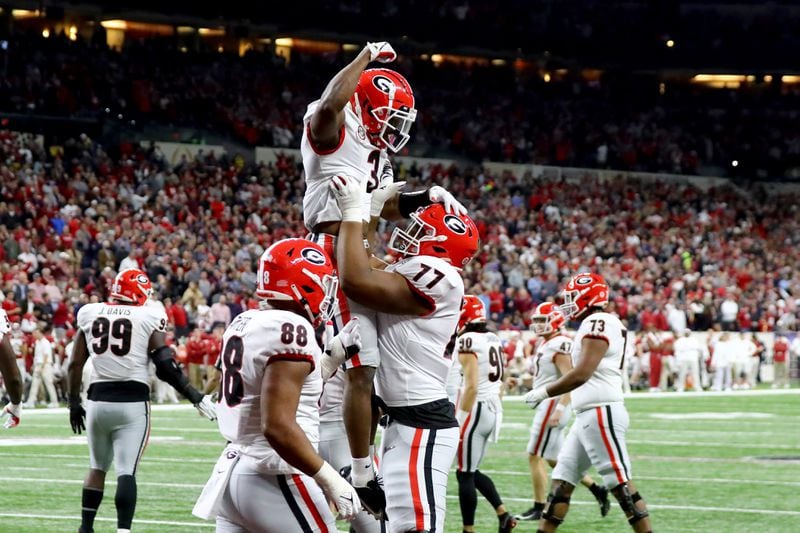 Georgia Bulldogs running back Zamir White (3) celebrates his 1-yard touchdown run with  offensive lineman Devin Willock (77) during the third quarter against the Alabama Crimson Tide at the 2022 College Football Playoff National Championship at Lucas Oil Stadium in Indianapolis on Monday, January 10, 2022. Curtis Compton / Curtis.Compton@ajc.com 