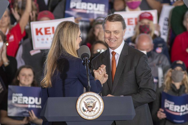 U.S. Sens. Kelly Loeffler (left) and David Perdue (right) embrace after speaking to a crowd at a rally in Gainesville, Georgia, on Friday, Nov. 20, 2020. (Alyssa Pointer/Atlanta Journal-Constitution/TNS)