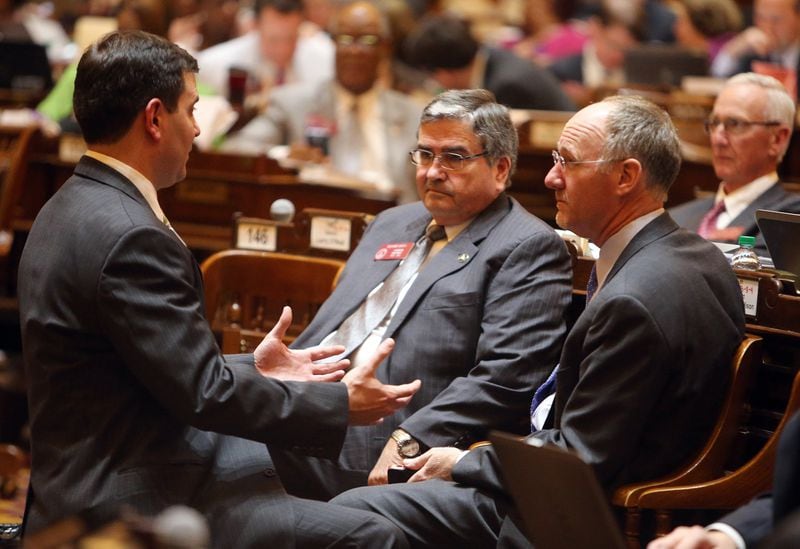 Terry Chastain, left, general council for the House Speaker’s office, talks with Reps. Richard Smith and Allen Peake on March 20, 2014. BEN GRAY / BGRAY@AJC.COM