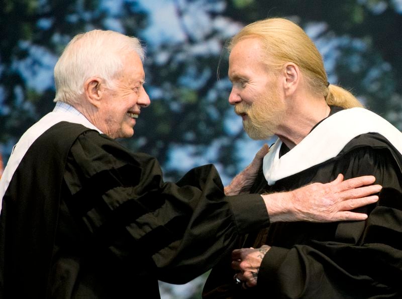 Former President Jimmy Carter and Rock and Roll Hall of Famer Gregg Allman embrace while Allman receives an honorary Doctor of Humanities degree during Mercer University's commencement at Hawkins Arena in Macon, Ga., on Saturday, May 14, 2016. (Jason Vorhees/The Macon Telegraph via AP)