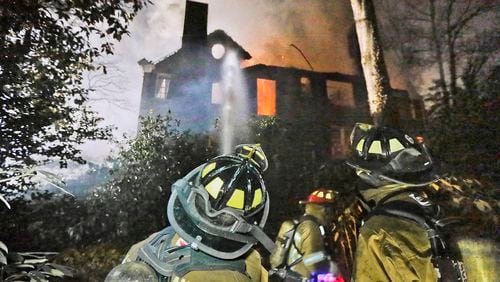 Two firefighters suffered minor injuries battling a Tuesday night blaze that destroyed a large, vacant home in the Druid Hills neighborhood of northeast Atlanta.