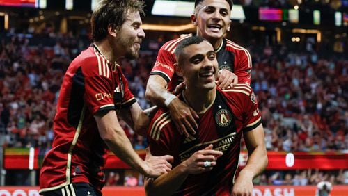 Atlanta United midfielder Thiago Almada (10) and  Saba Lobzhanidze (9) celebrate with Atlanta United forward Giorgos Giakoumakis (7)  after he scored the first goal of his team during the first half against the Chicago Fire at Mercedes-Benz Stadium on Sunday, March 31, 2024.
 Miguel Martinez / miguel.martinezjimenez@ajc.com