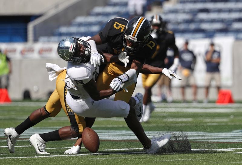 Norcross wide receiver Isaiah McKoy (13) can't hold onto a catch as he is hit by a Colquitt County defender in the first half of their game during the Corky Kell Classic at Georgia State Stadium Saturday, August 19, 2017, in Atlanta.