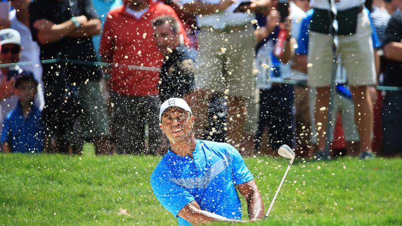 Tiger Woods supplies one of the standard blast-out-of-the-bunker photos Thursday during the first round of the BMW Championship. (Photo by Andrew Redington/Getty Images)