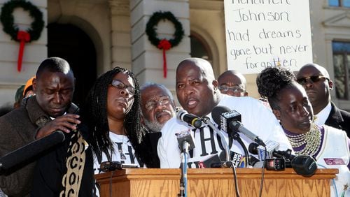 Jackie and Kenny Johnson (center) speak to the crowd during a “Who Killed K.J.” rally for their son Kendrick Johnson in Atlanta in December 2013. PHIL SKINNER / PSKINNER@AJC.COM