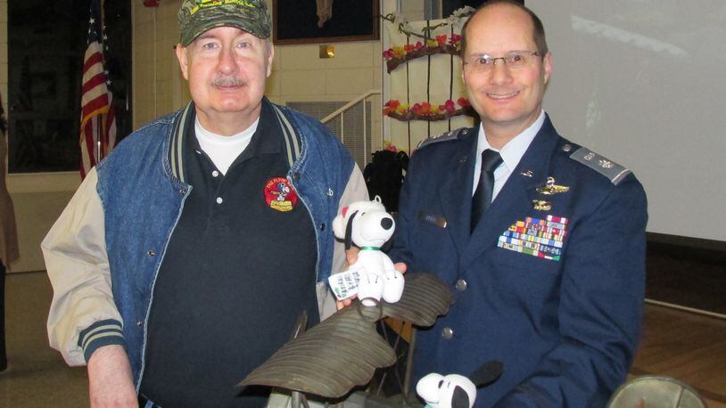 Vietnam War veteran Joe Congleton (left) and Lt. Col Brian Berry show off the model of a World War I plane piloted by the cartoon character Snoopy. The Sandy Springs Cadet Squadron of the Civil Air Patrol presented it to Congleton, who designed the squadron s Snoopy-themed patch in 1967.