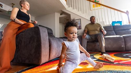 Akil Sanders, right, with his wife, Stefanie, and their daughter, Nola, in their Old Fourth Ward home. Not all Atlanta residents agree about how to tackle Atlanta's crime surge. But many like Sanders see the issue intertwined with joblessness, poverty, desperation amid the coronavirus pandemic and shortages in affordable housing. Targeting those problems, they said, would make an impact. 
 (Jenni Girtman for The Atlanta Journal-Constitution)