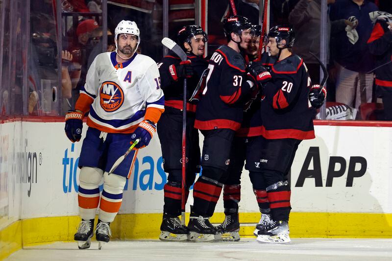 Carolina Hurricanes' Andrei Svechnikov (37) celebrates his goal with Sebastian Aho (20) as New York Islanders' Cal Clutterbuck (15) skates by during the first period in Game 5 of an NHL hockey Stanley Cup first-round playoff series in Raleigh, N.C., Tuesday, April 30, 2024. (AP Photo/Karl B DeBlaker)