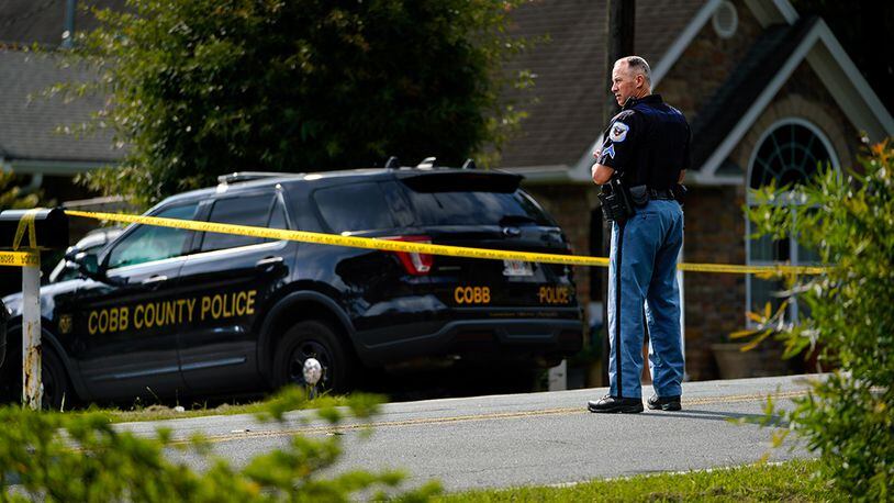 A Cobb County police officer stands outside at a shooting scene on Olive Spring Road. (Photo: Ben Hendren for The Atlanta Journal-Constitution)