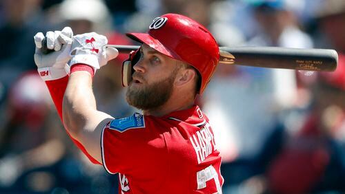 Washington Nationals right fielder Bryce Harper (34) follows through on abase hit during a spring training baseball game against the New York Mets Thursday, March 8, 2018, in West Palm Beach, Fla. (AP Photo/John Bazemore)