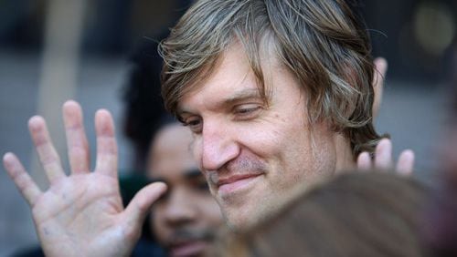 Tim Franzen, a leader of Occupy Atlanta, waves along with other protesters that were arrested and released during a press conference in front of Atlanta City Jail.