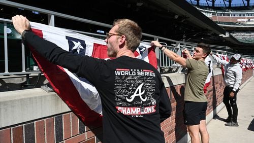 October 7, 2022 Atlanta - From left, Evan Foertsch, Bruce Stephens and Clayton Rounsaville install flag buntings prior to National League Division Series (NLDS) starting next Tuesday at Truist Park on Friday, October 7, 2022. (Hyosub Shin / Hyosub.Shin@ajc.com)