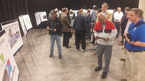Consultants and stakeholders at Fulton County Executive Airport look over plans to lengthen the main runway and replace the crosswind runway with hangars at a public meeting Feb. 16, 2023,